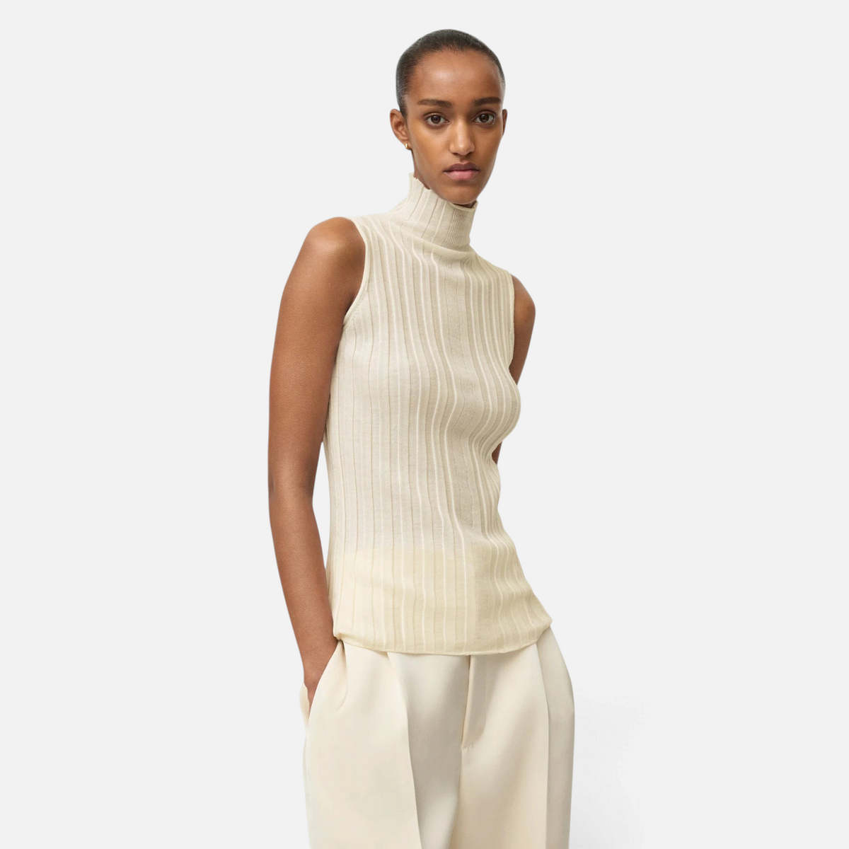 Model wearing a Shop Rescue Spa cream ribbed wool turtleneck singlet with a sleeveless design