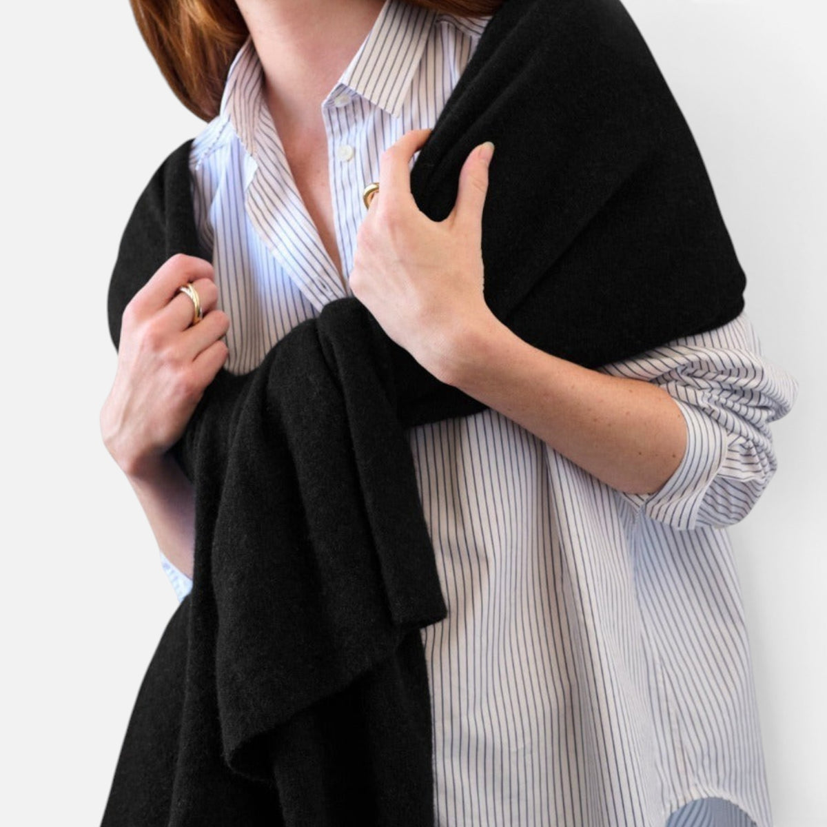 Shop Rescue Spa black cashmere travel wrap draped over shoulders worn with a striped button-down shirt