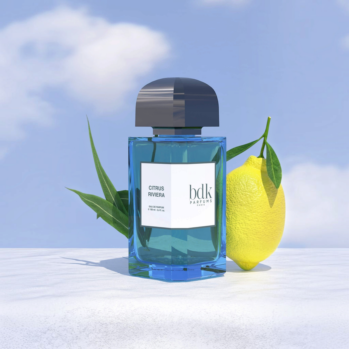 Shop Rescue Spa Citrus Riviera perfume bottle with a fresh lemon and green leaves against a blue sky background.