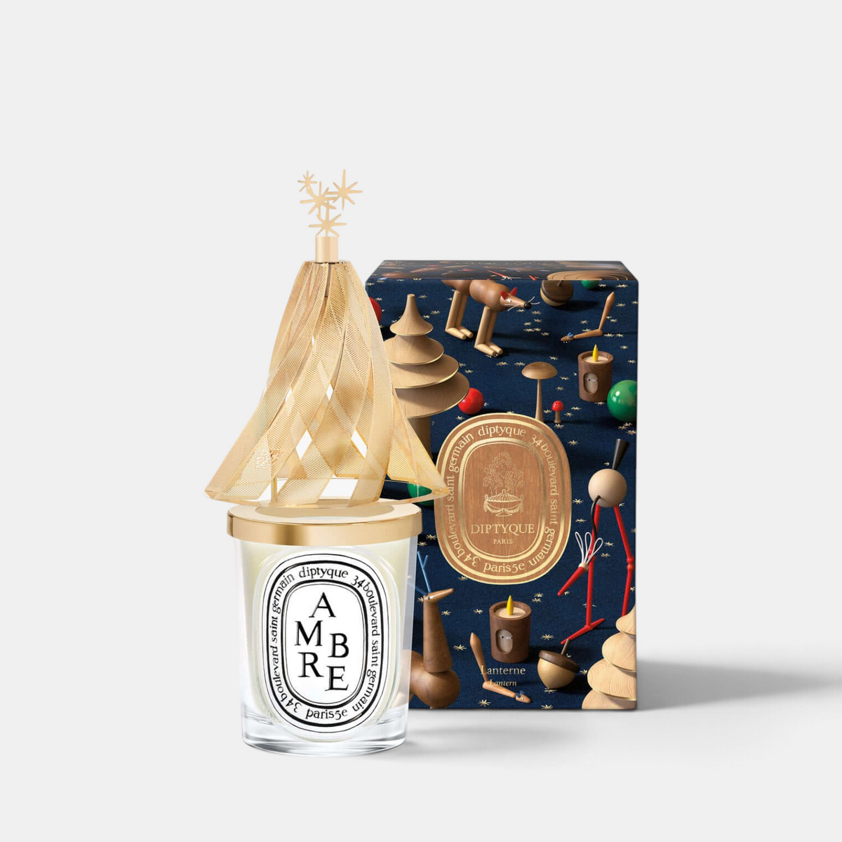 Shop Rescue Spa Diptyque holiday lantern with golden pine tree silhouette and star topper on a classic candle