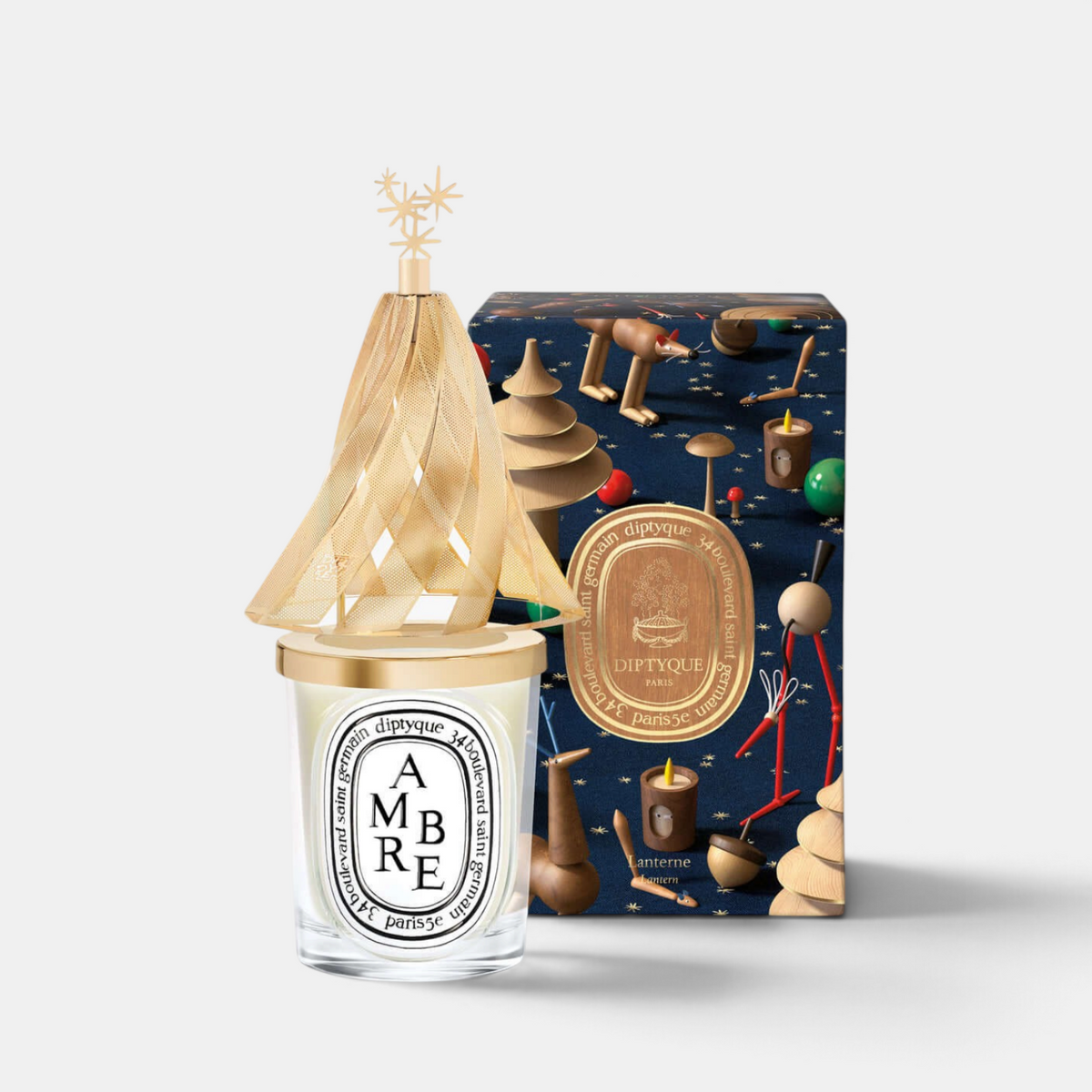 Shop Rescue Spa Diptyque holiday lantern with golden pine tree silhouette and star topper on a classic candle