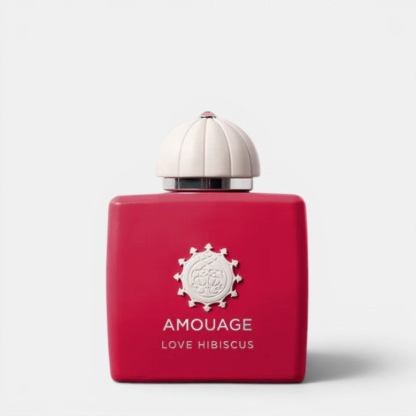 Red Amouage perfume bottle with white cap on a light gray background
