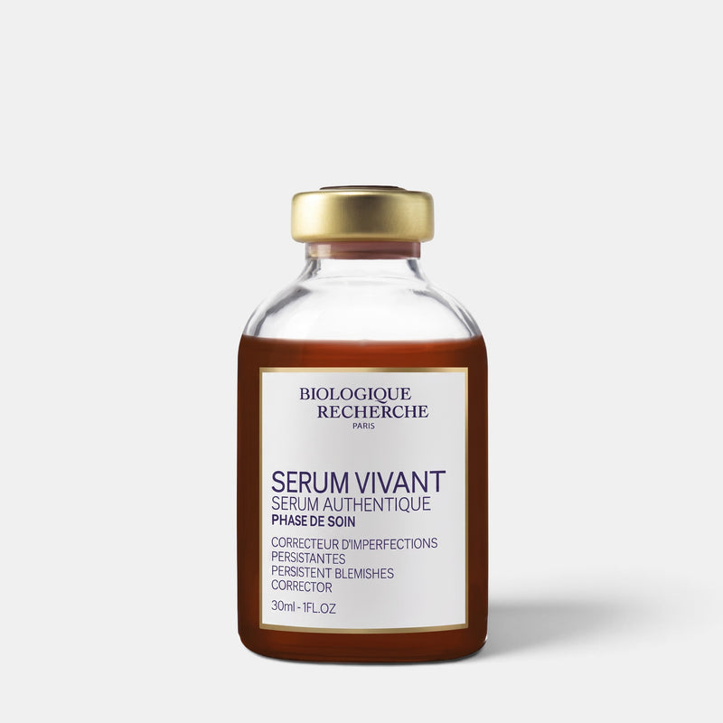 A 30ml glass vial of Biologique Recherche 'Serum Vivant' blemish corrector, featuring a gold cap and a cream-colored label with dark blue text, set against a light gray background.