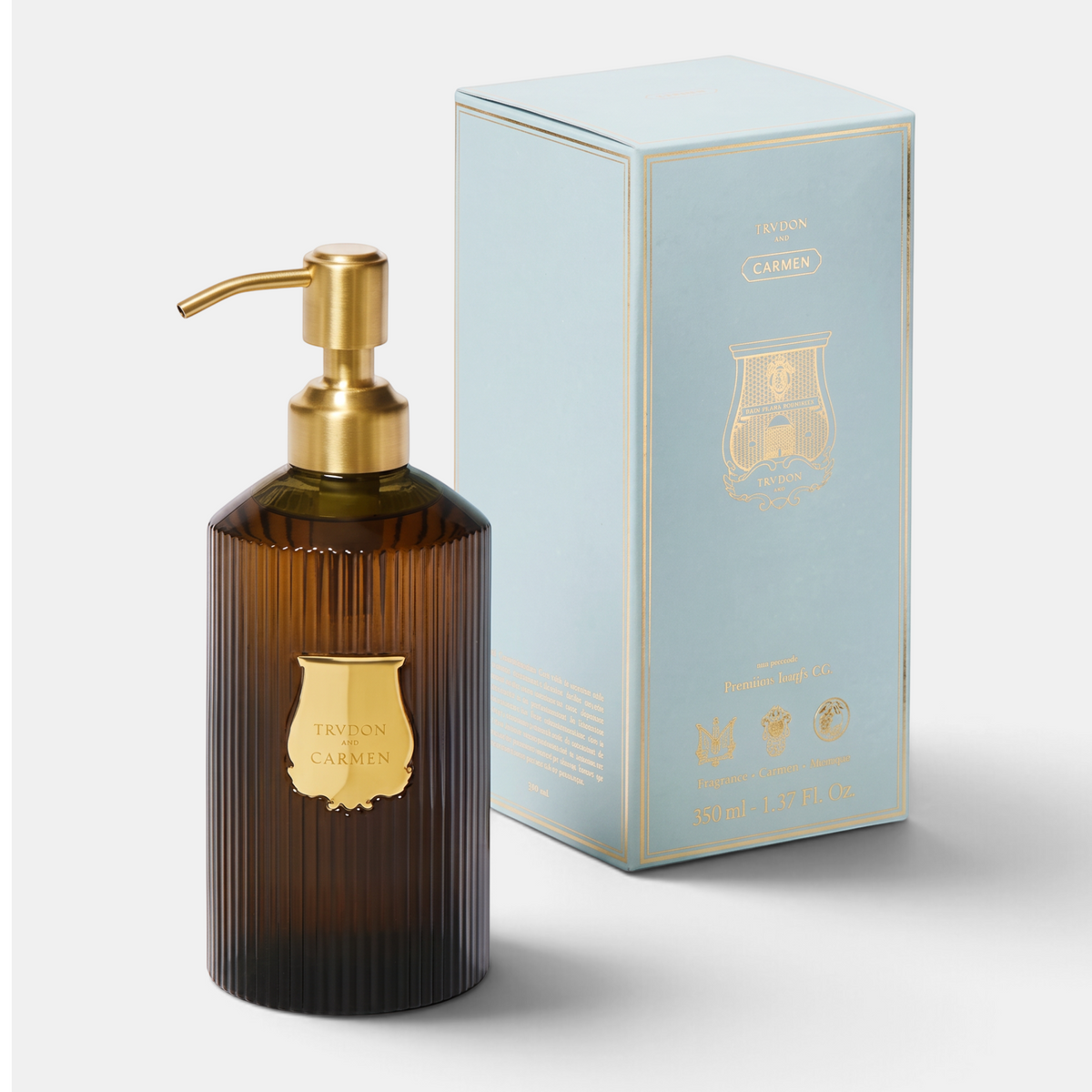 Shop Rescue Spa Trudon Carmen scented hand soap in a ribbed amber glass bottle with gold pump next to its blue box.