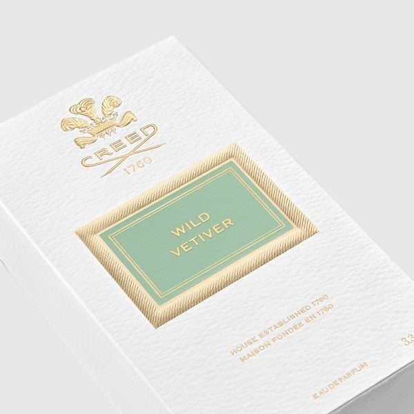 Angled view of Creed Wild Vetiver perfume box on a clean background, highlighting side and front panels of the packaging.