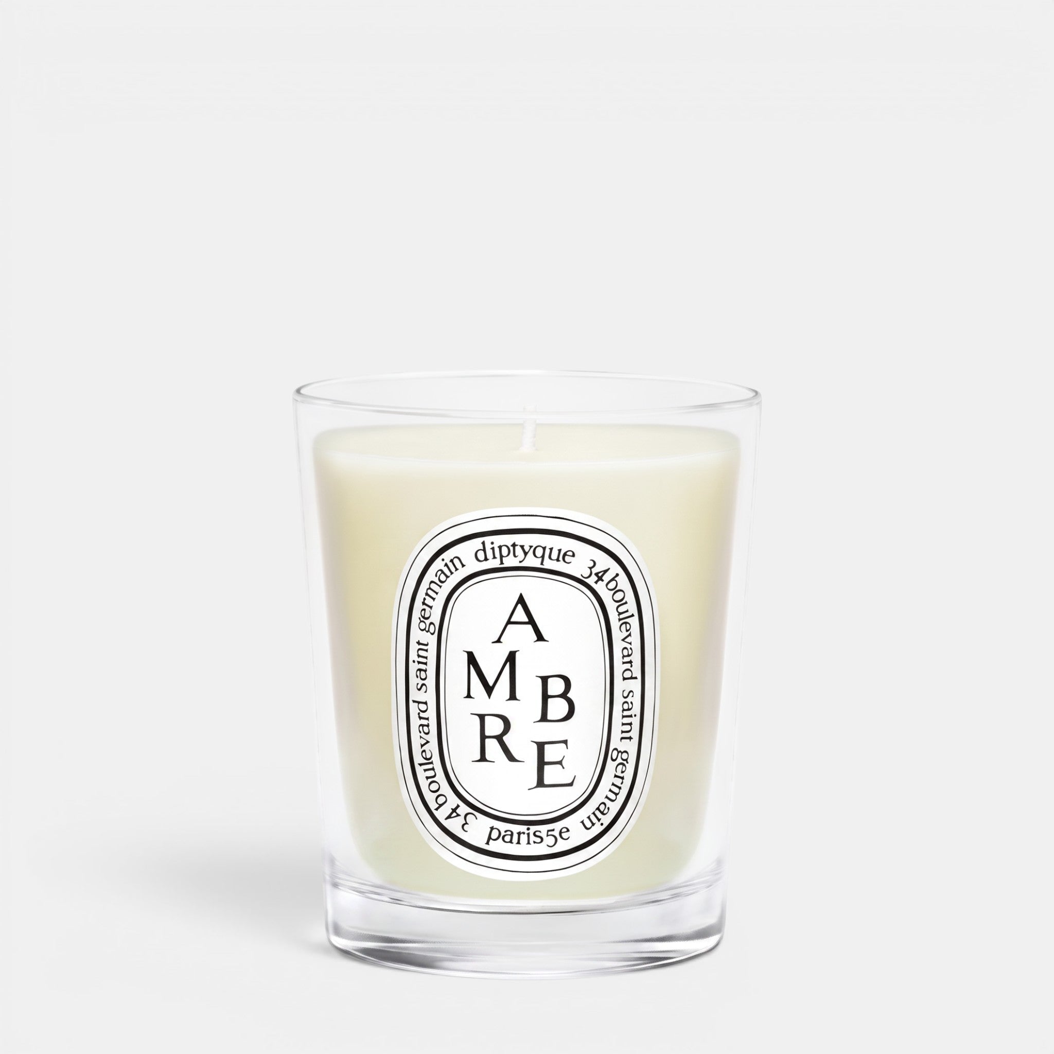 Shop Rescue Spa Ambre scented candle in a clear glass jar with a signature oval white label and woody fragrance.