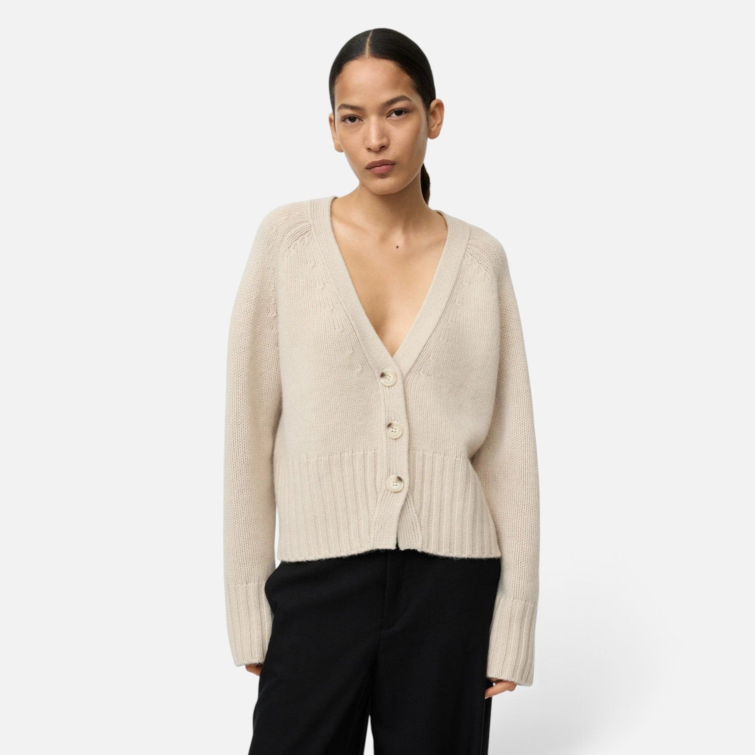 Shop Rescue Spa beige chunky knit cashmere V-neck cardigan with button front worn by a model