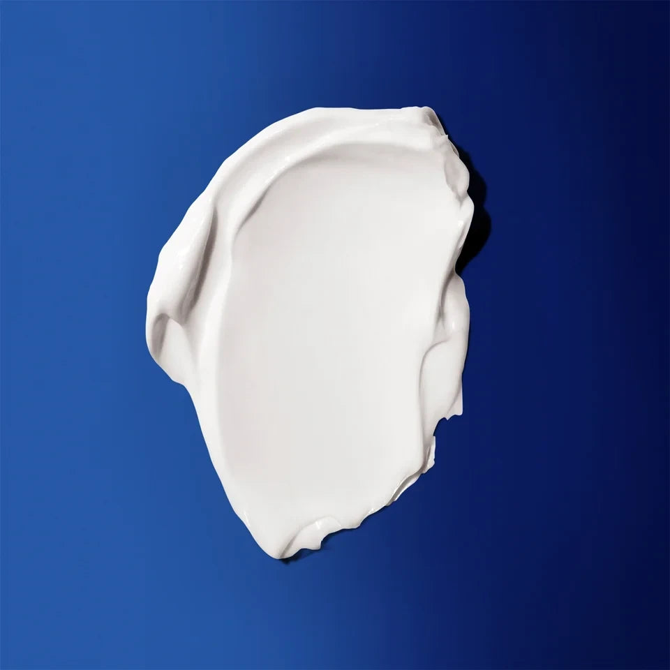 Shop Rescue Spa The Body Cream white moisturizing cream texture swatch on a deep blue background