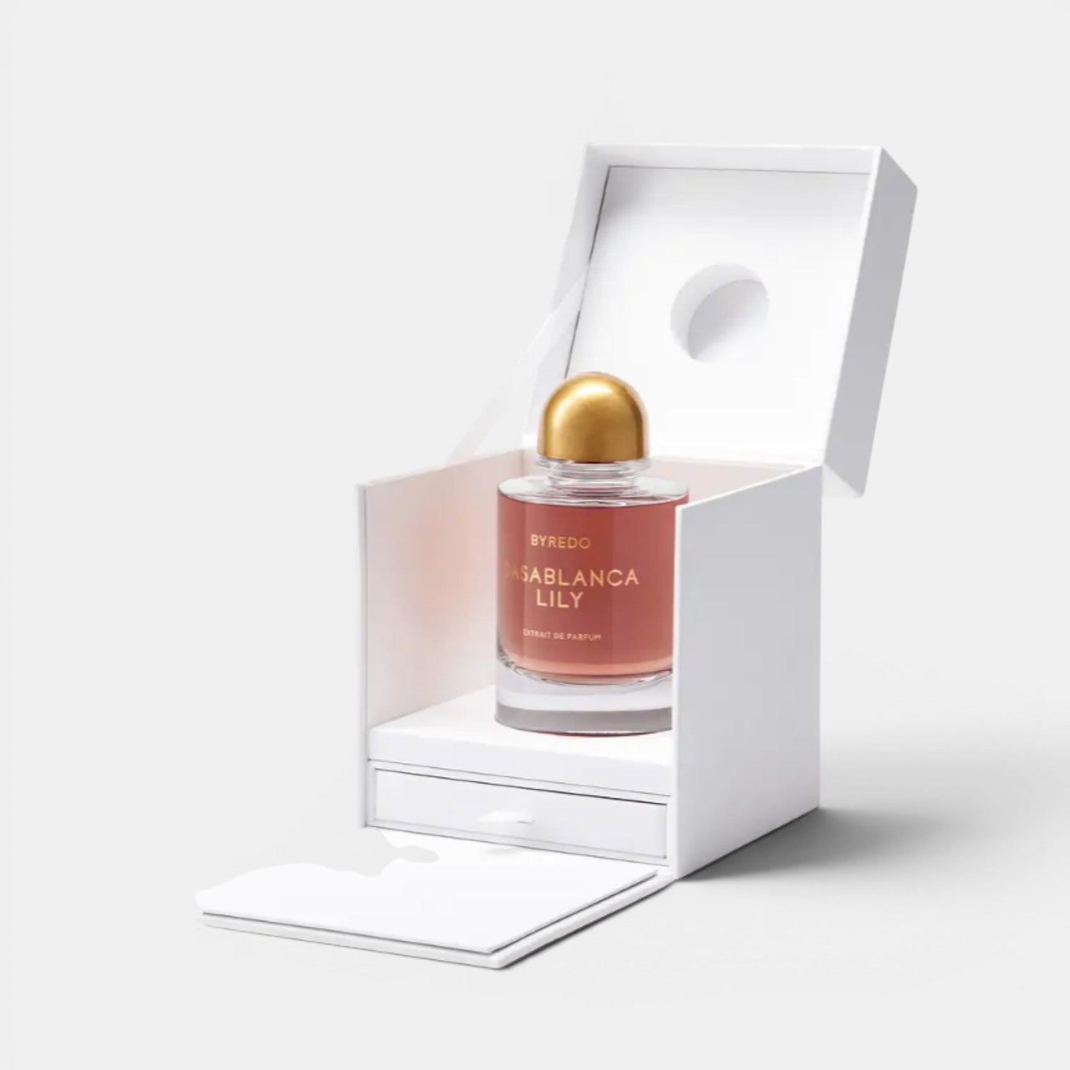 Shop Rescue Spa BYREDO Casablanca Lily Extrait De Parfum in a pink-hued glass bottle with a gold cap, presented in a white box.