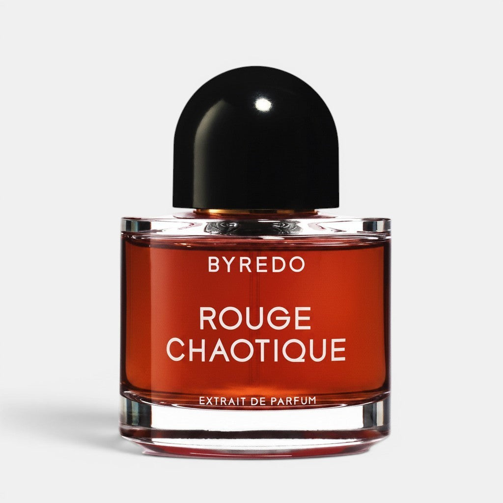 Shop Rescue Spa BYREDO Rouge Chaotique Extrait De Parfum in a red glass bottle with a black dome cap. Notes of saffron, blackcurrant, bergamot, leather, plum, praline, oud, patchouli, and papyrus.