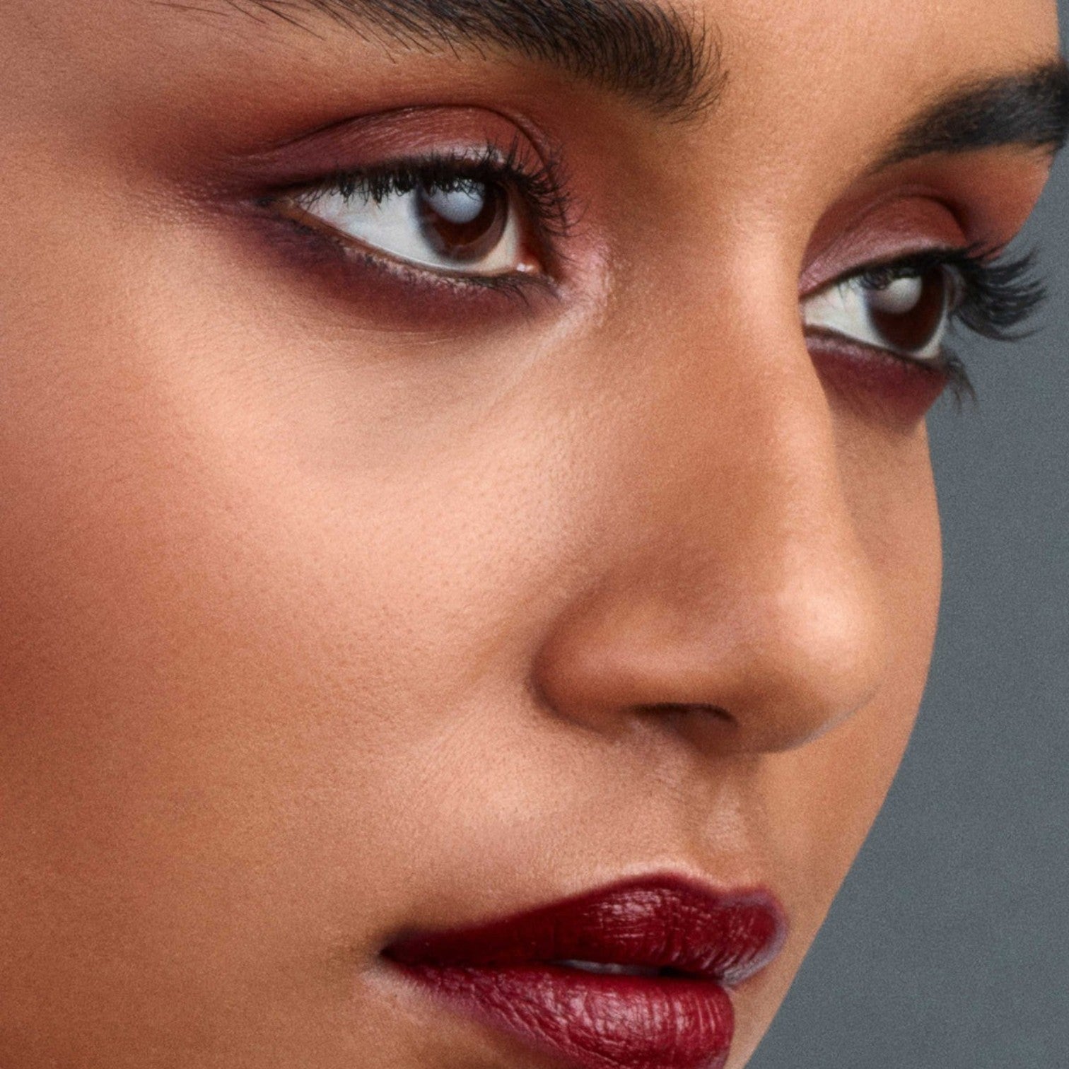 Shop Rescue Spa Eye Pods Les Nuits eyeshadow trio applied on a model with deep red and champagne tones for a luminous finish