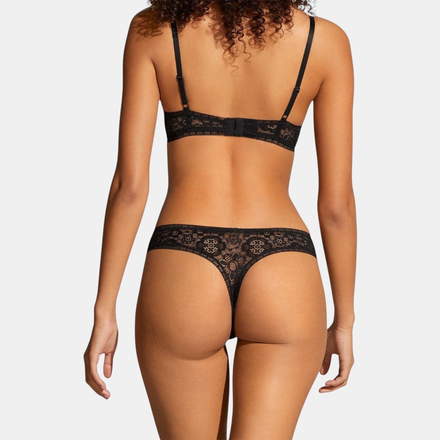 Shop Rescue Spa Frivole black lace tanga panty with matching bra, viewed from the back on a model.