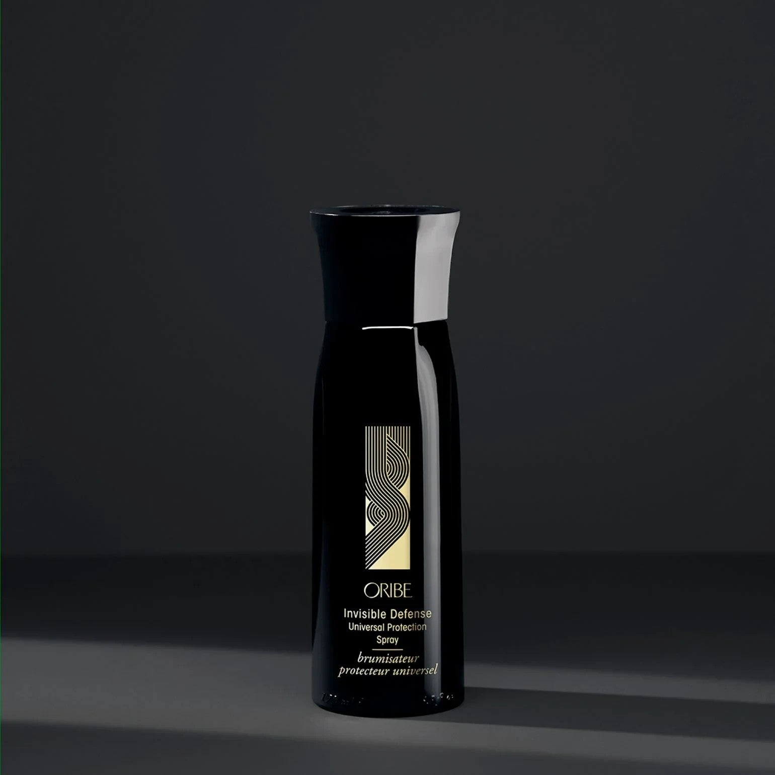 Shop Rescue Spa Oribe Invisible Defense Universal Protection Spray in a sleek black bottle for heat and UV protection.