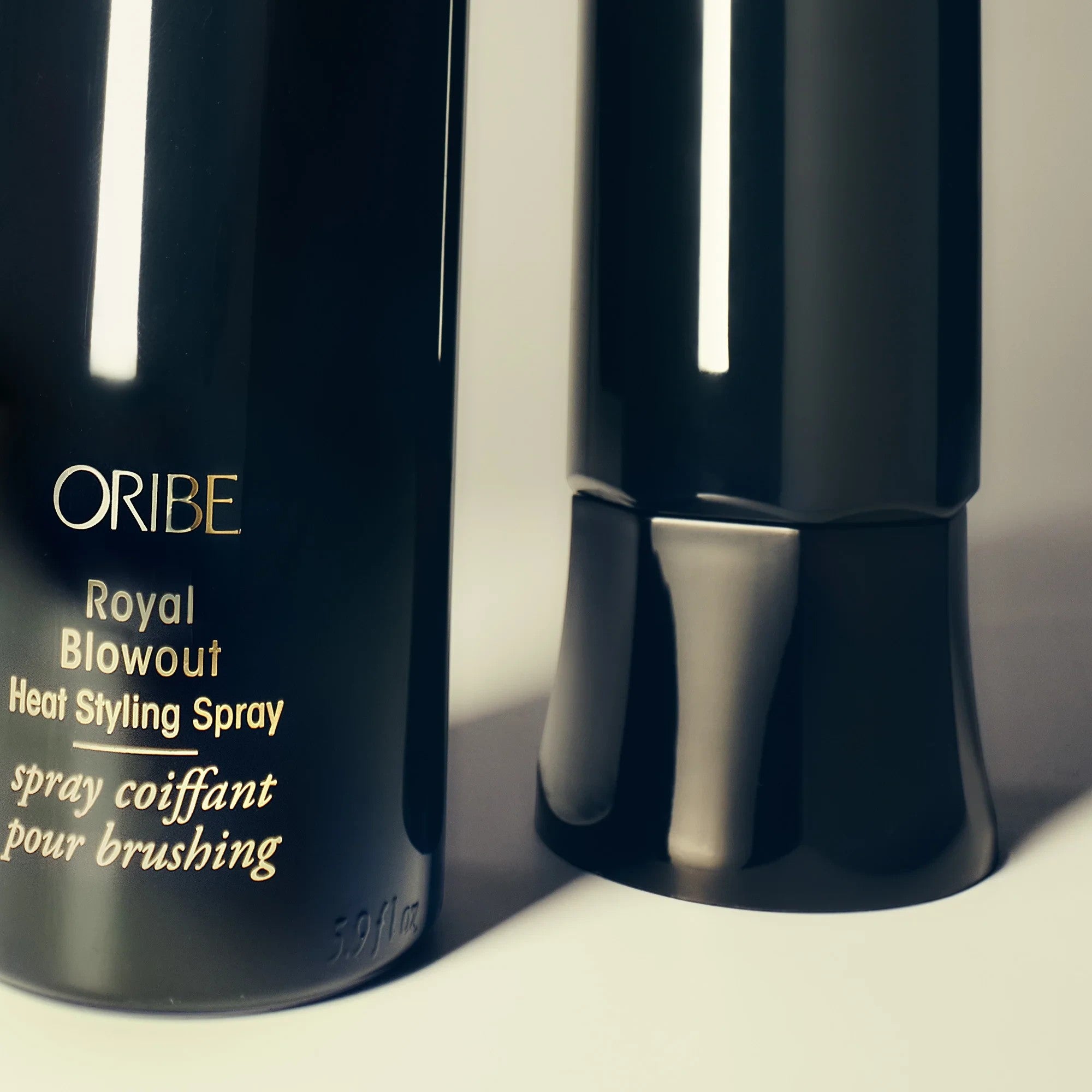 Shop Rescue Spa Oribe Royal Blowout Heat Styling Spray in a black bottle with gold text for heat protection.