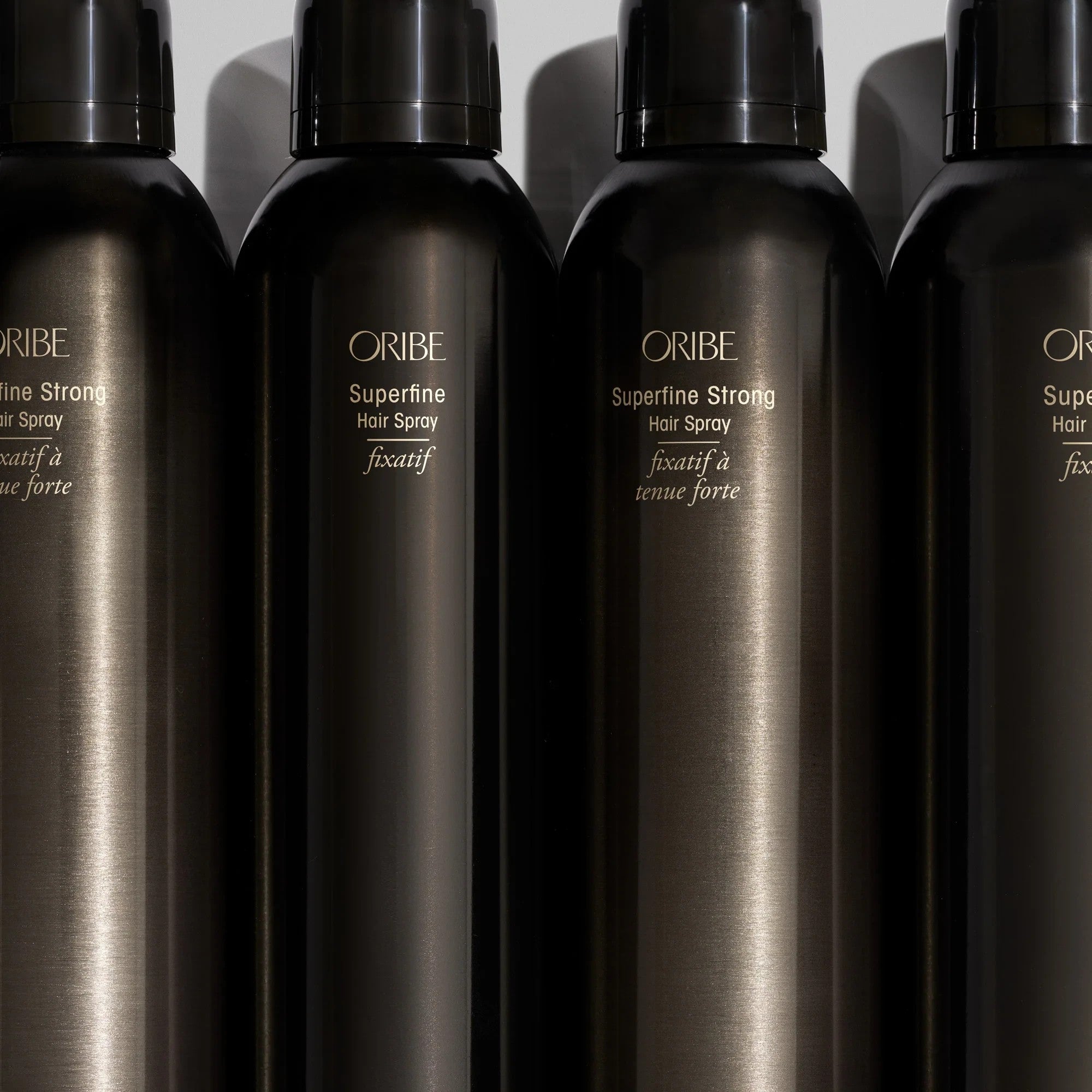 Shop Rescue Spa Oribe Superfine Hair Spray bottles in a row with black metallic finish and elegant branding