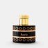 A luxury cylindrical perfume bottle with a glossy black body, featuring a gold cap, gold geometric patterns, and a central black band with the name &