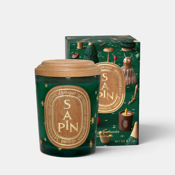 Shop Rescue Spa Diptyque Sapin holiday candle in a green glass jar with a wooden lid and festive forest illustration