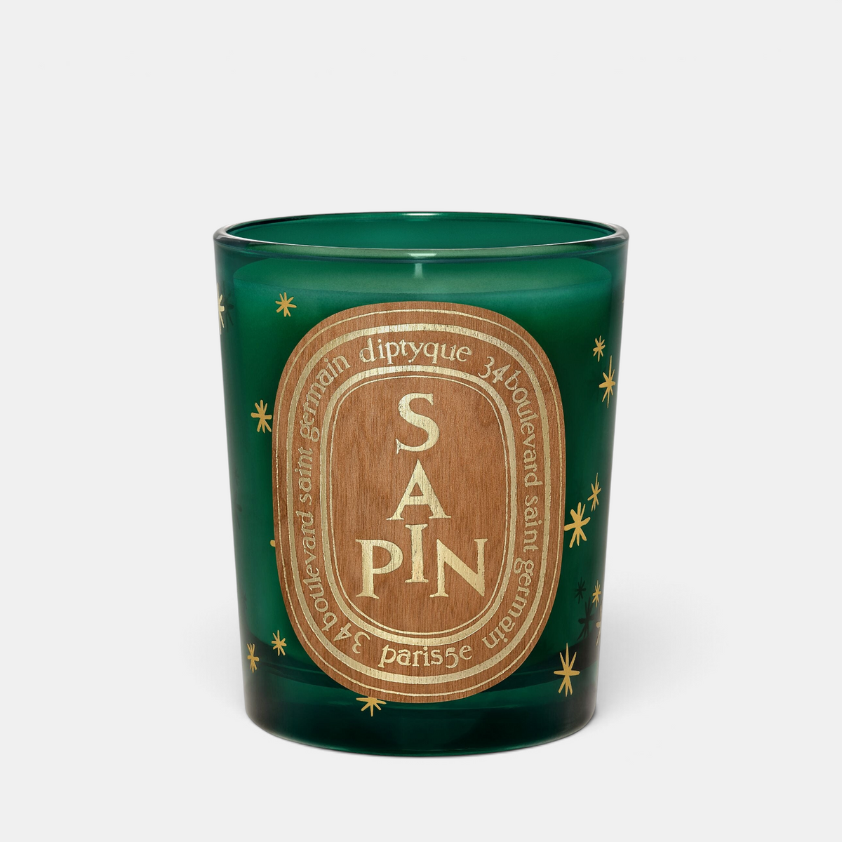 Shop Rescue Spa Diptyque Sapin holiday scented candle in a green glass jar with gold star accents