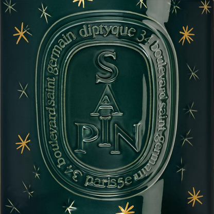 Shop Rescue Spa Diptyque Sapin holiday candle in dark green glass with gold star accents and embossed lettering