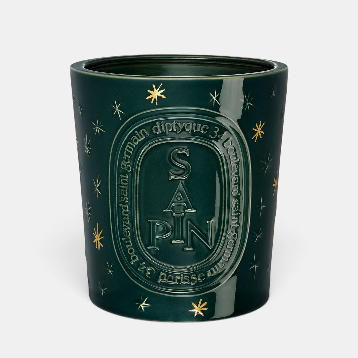 Shop Rescue Spa Diptyque Sapin holiday candle in a dark green glass jar with gold star accents and embossed lettering.