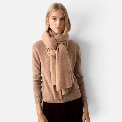 Shop Rescue Spa beige cashmere travel wrap worn as a scarf by a blonde woman in a matching sweater