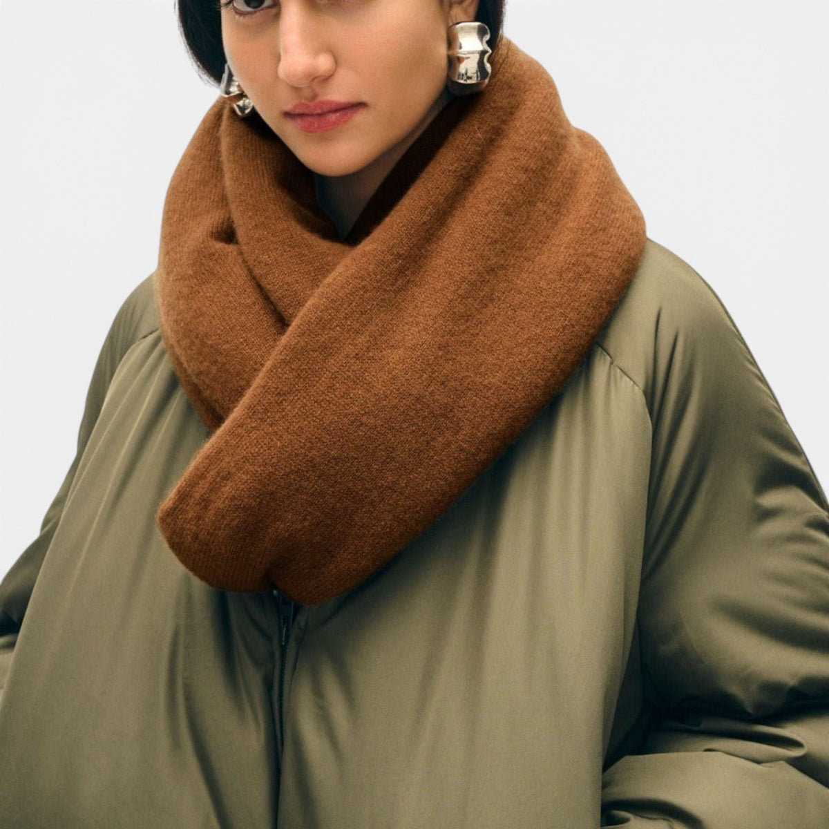 Shop Rescue Spa brown cashmere travel wrap worn as a cozy scarf by a woman in an olive green jacket