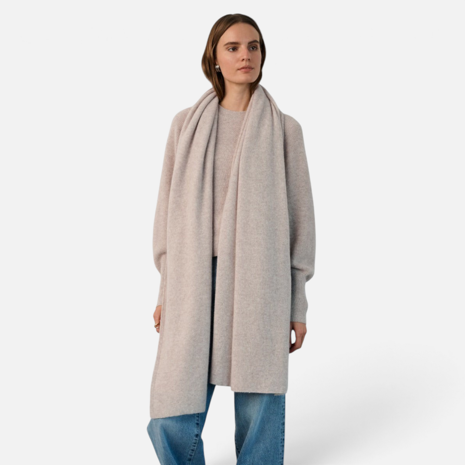 Shop Rescue Spa beige cashmere travel wrap worn by a woman over a matching sweater and blue jeans