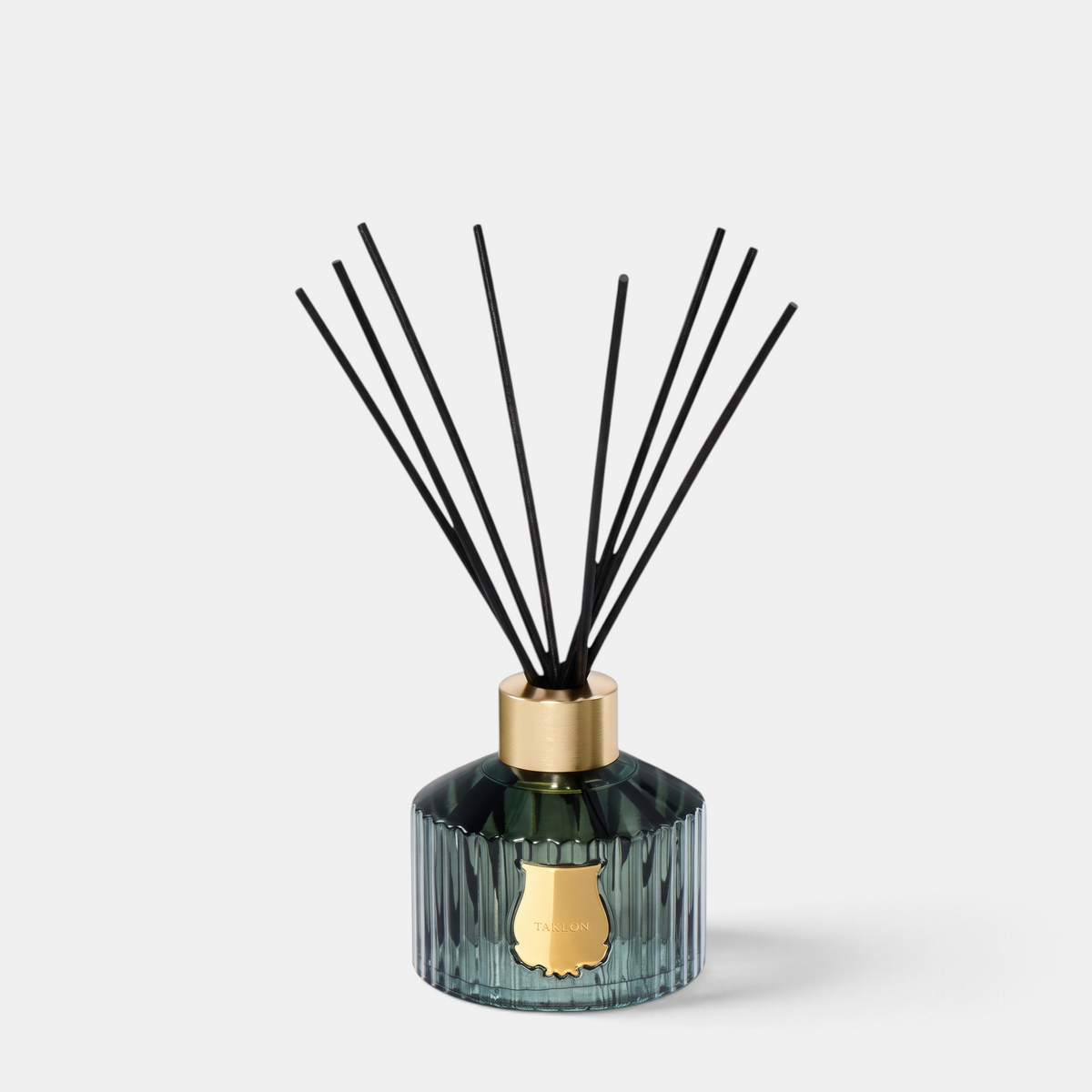 Shop Rescue Spa Trudon Figuerie home diffuser in a fluted green glass vessel with black reeds and gold emblem.
