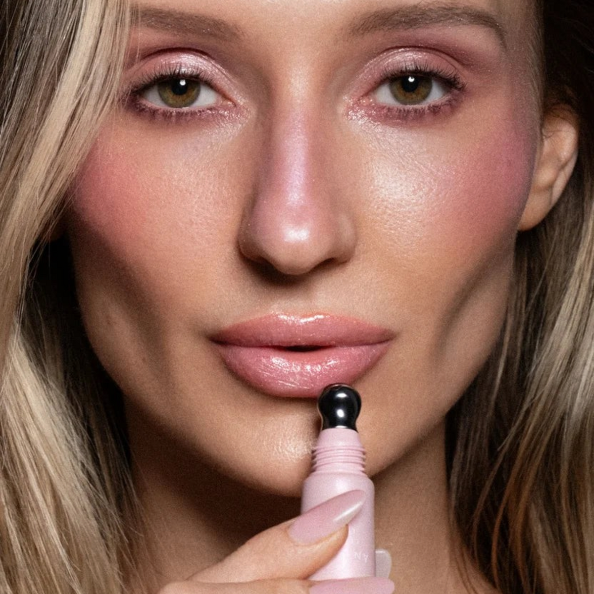 Shop Rescue Spa ÂN-GLOSS Ceramide Lip Tint in shimmery pink applied to lips with a cooling metal applicator tip