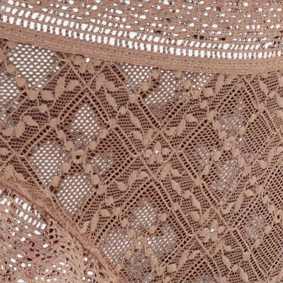Close-up of a beige crochet lace fabric with an intricate floral and geometric openwork pattern.
