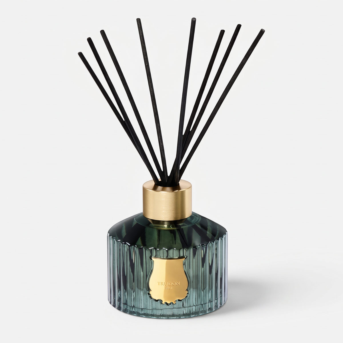 Shop Rescue Spa Trudon Figuerie Grand Diffuser in a ribbed green glass vessel with black reeds and gold emblem.