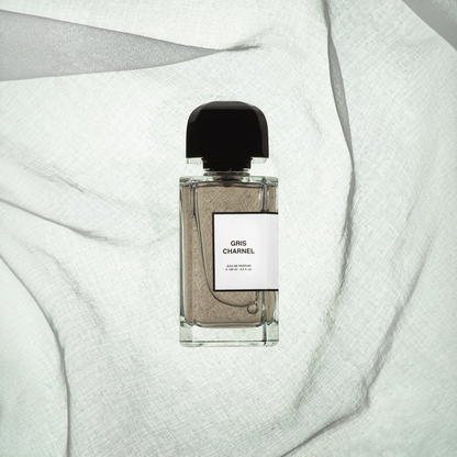 Shop Rescue Spa Gris Charnel eau de parfum in a glass bottle with a black cap on a textured white fabric background.