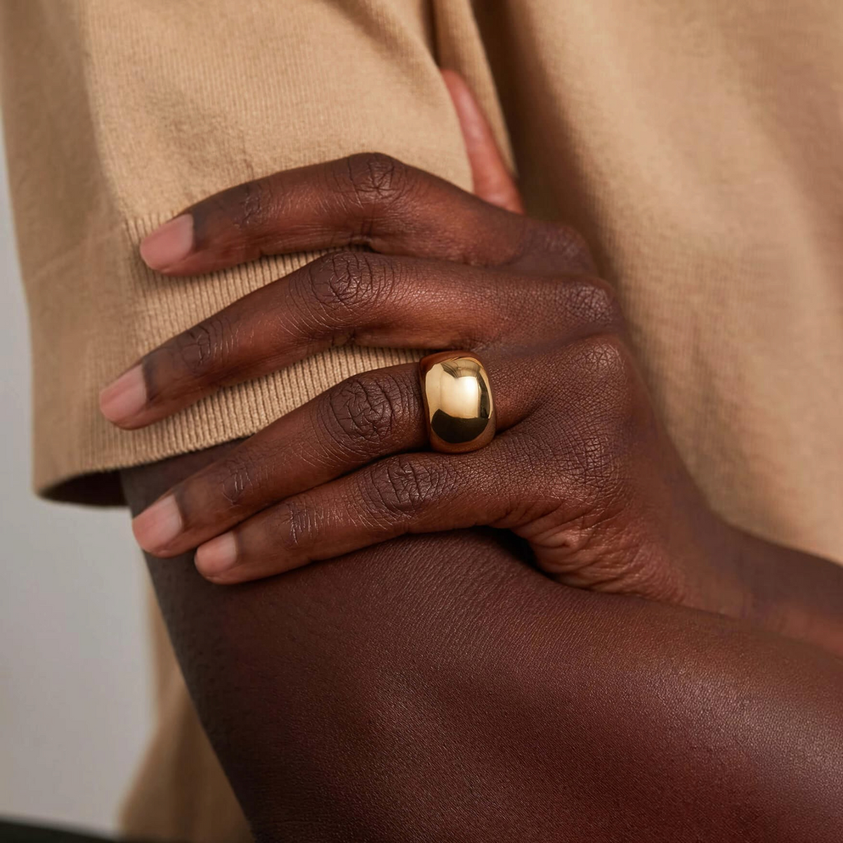 Shop Rescue Spa Tate gold signet ring with a sculptural, rounded rectangular design worn on a finger.