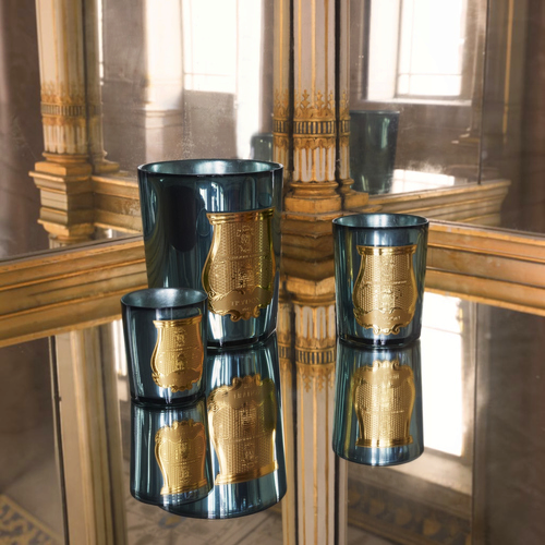 Shop Rescue Spa Fir holiday candles in celadon mirror-finish glass with gold emblem on a reflective surface