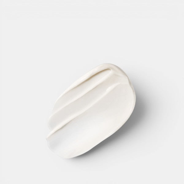 Cream swatch showing the rich, smooth texture of The Overnight Restorative Cream with a soft shadow on a grey background.