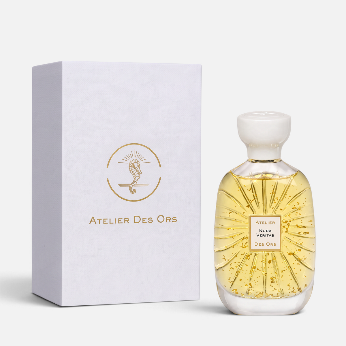 Shop Rescue Spa Atelier Des Ors Nuda Veritas perfume bottle with gold flakes and white box on a neutral background