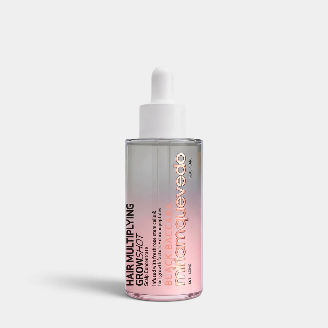 A clear glass dropper bottle of mihamqueedo Hair Multiplying Serum with a pink-to-white gradient liquid, set against a light gray background.