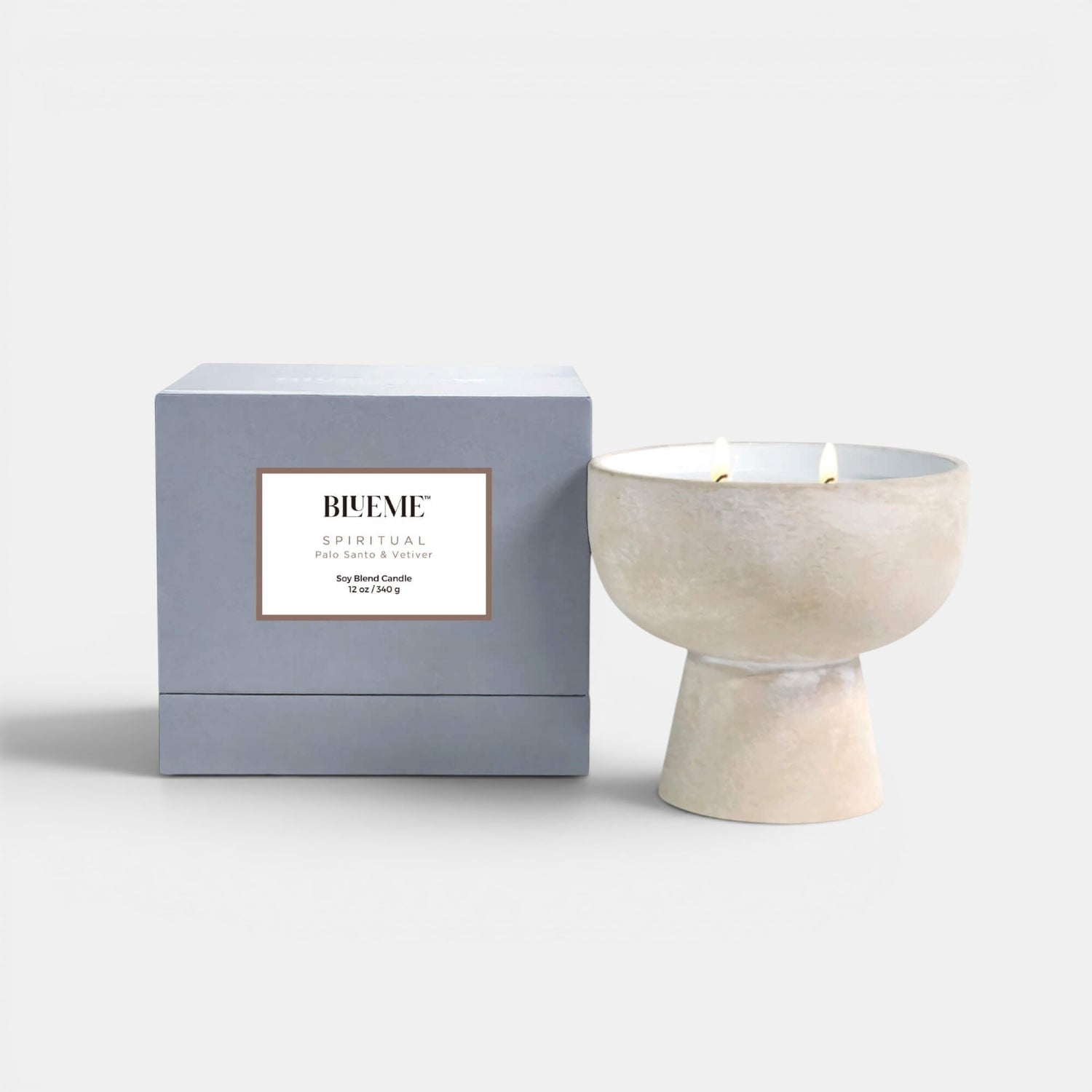 Blueme Fragrance spiritual ceramic candle positioned upright showing the lit candle and the box. Palo Santo and Vetiver scented candle.