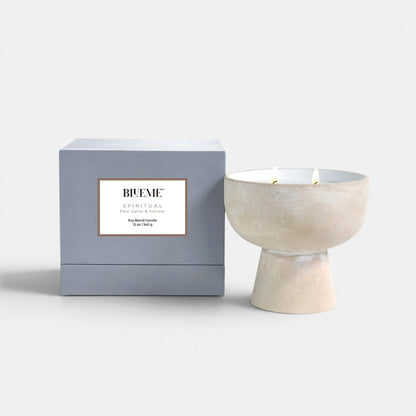 Blueme Fragrance spiritual ceramic candle positioned upright showing the lit candle and the box. Palo Santo and Vetiver scented candle.