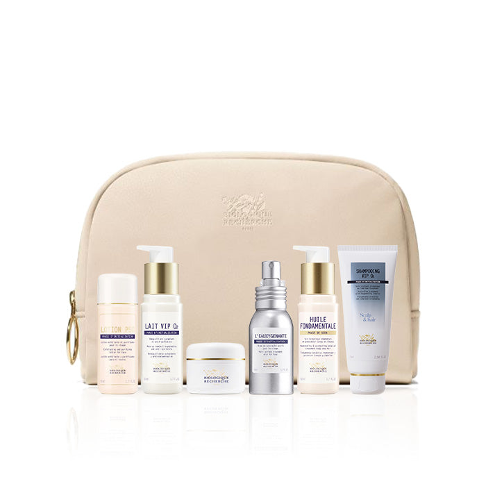 Set of Biologique Recherche Travel Essentials skincare products in a beige travel bag on a white background