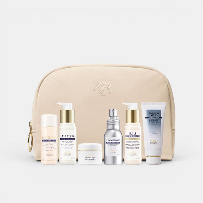 Set of Biologique Recherche Travel Essentials skincare products in a beige travel bag on a white background