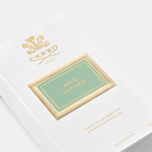 Angled view of Creed Wild Vetiver perfume box on a clean background, highlighting side and front panels of the packaging.