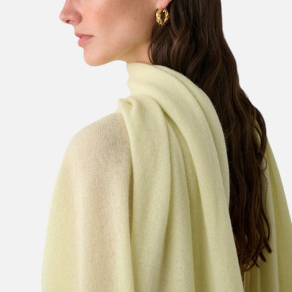 Shop Rescue Spa pale yellow cashmere travel wrap draped over a woman&
