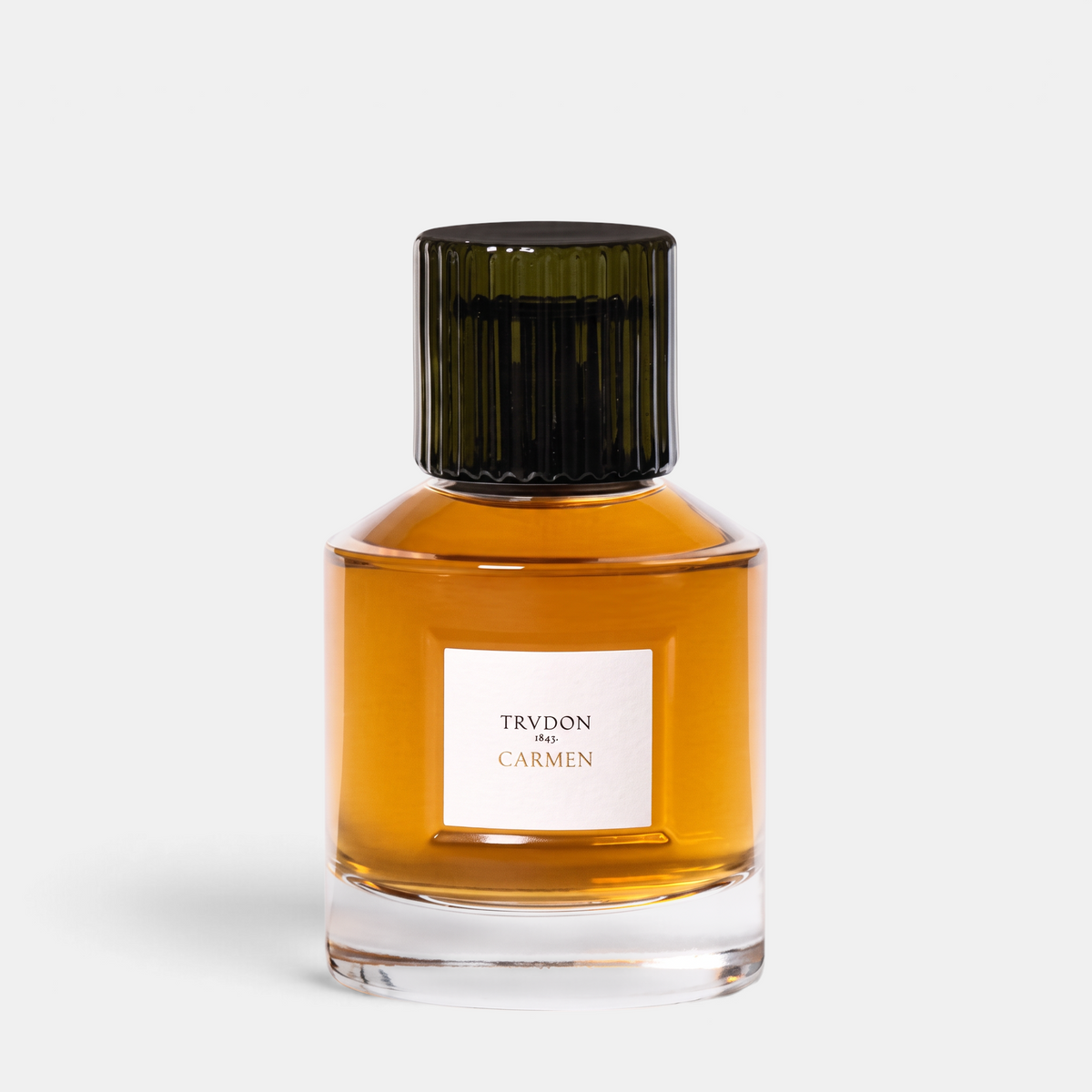 Shop Rescue Spa Trudon Carmen Eau de Parfum in a clear glass bottle with a dark ribbed cap and amber fragrance liquid.