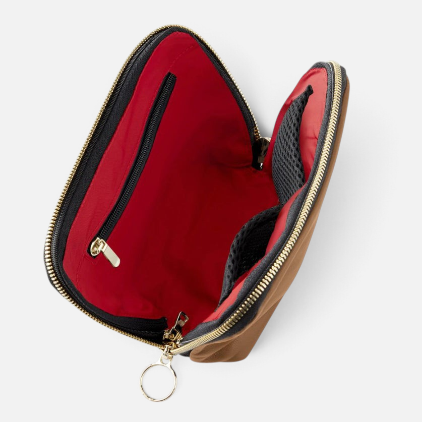 Shop Rescue Spa leather makeup bag in tan with a vibrant red interior, featuring mesh pockets and a zip-out liner.