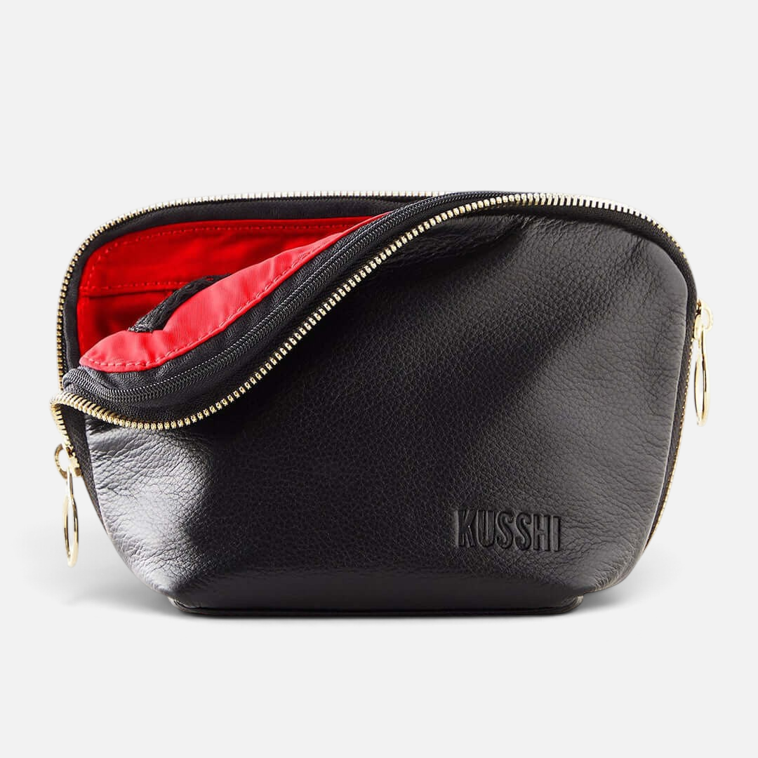 Shop Rescue Spa black leather Everyday Makeup Bag with a vibrant red interior and gold zipper hardware