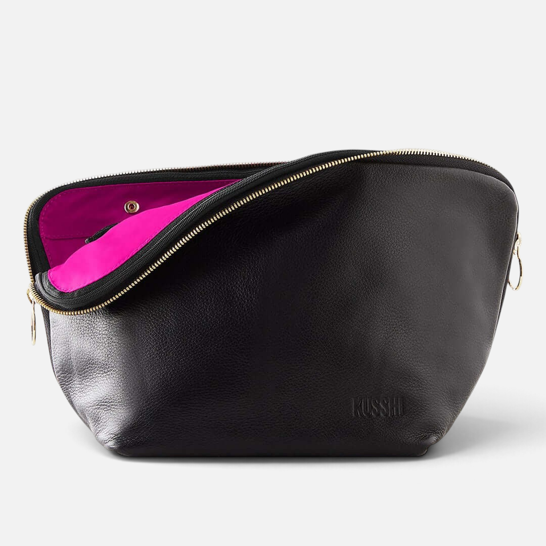 Shop Rescue Spa Vacationer makeup bag in black leather with a vibrant pink interior and gold zipper detail.