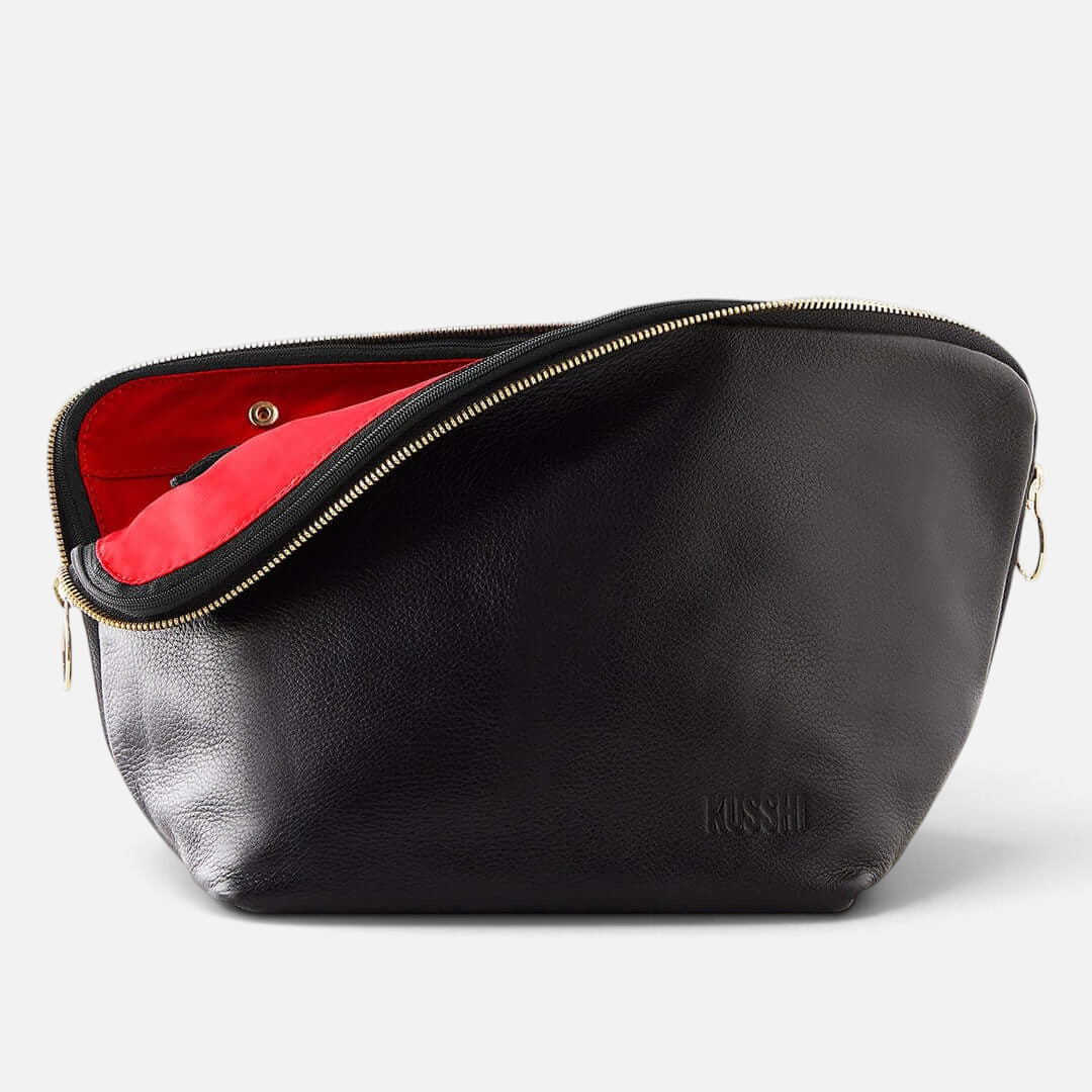Shop Rescue Spa Vacationer makeup bag in black leather with a vibrant red interior and gold zipper detail.