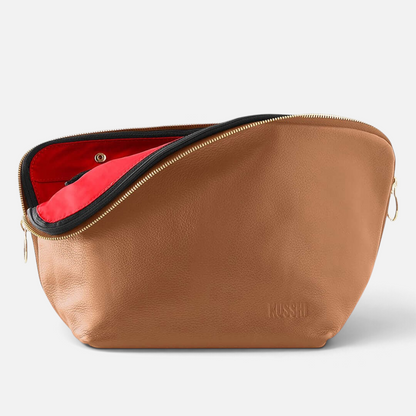 Shop Rescue Spa Vacationer makeup bag in tan leather with a vibrant red interior and gold zipper detail.