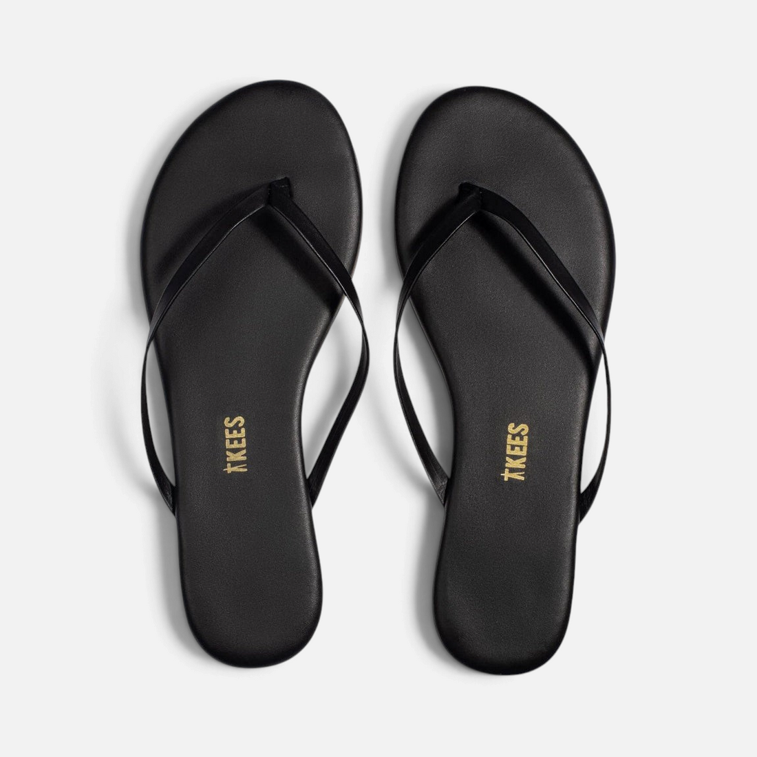 Shop Rescue Spa Liners Sable matte black cowhide leather flip flops with rubber outsoles, top view.